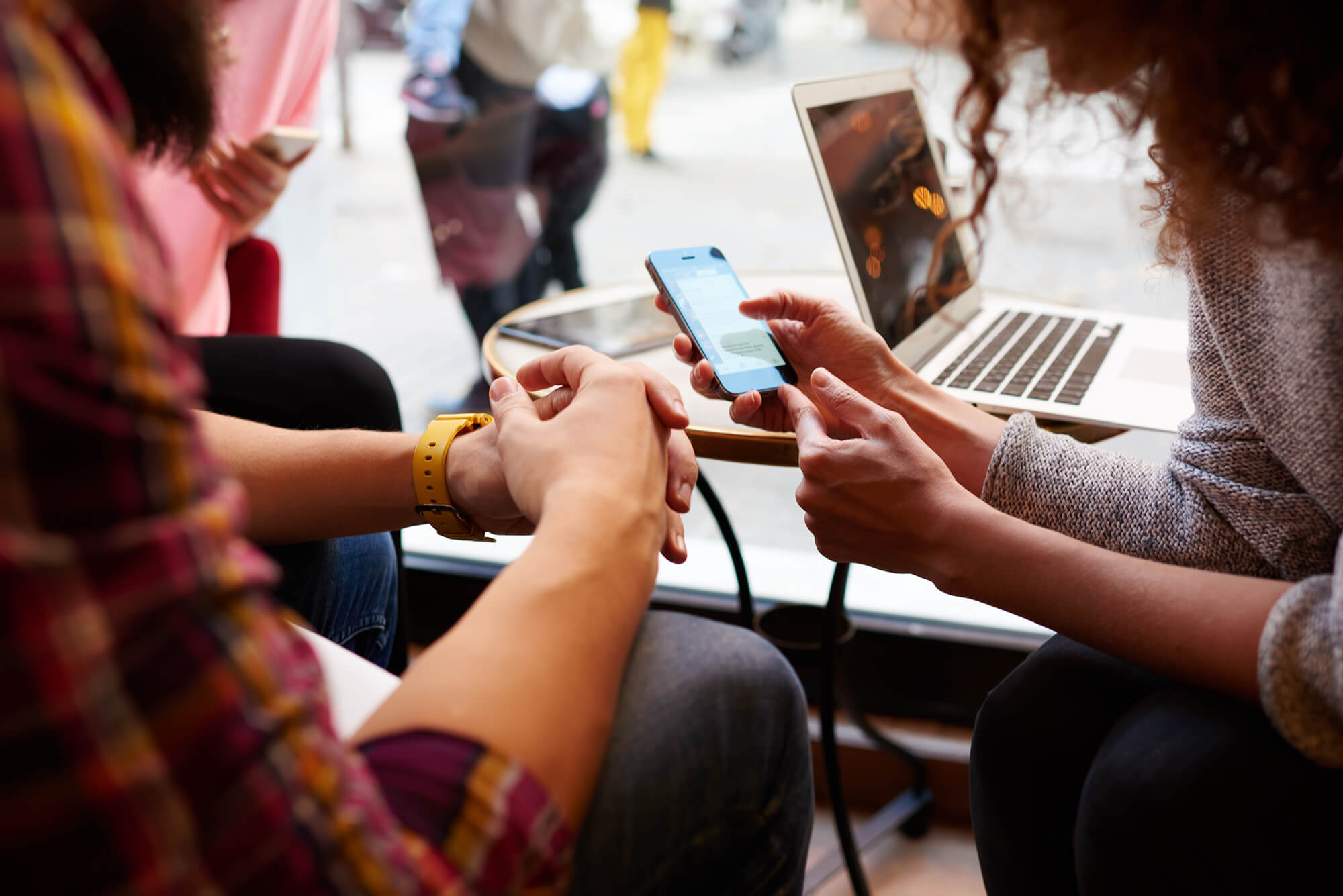 friends playing on a mobile phone and laptop